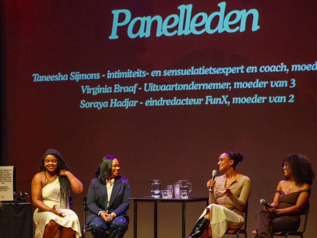 Panelgesprek met vier deelnemers op het podium